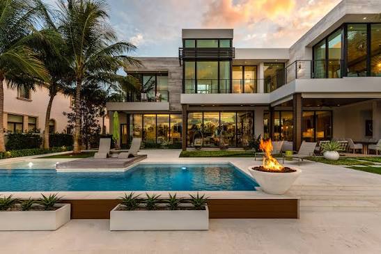 Modern home with pool and fire feature at dusk