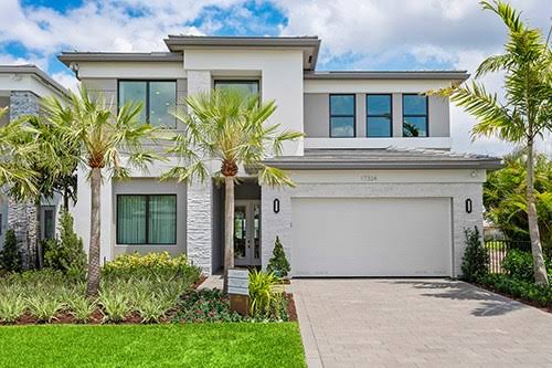 Modern white estate home with palm trees