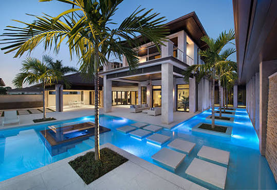 Modern South Florida home patio and pool lit at dusk