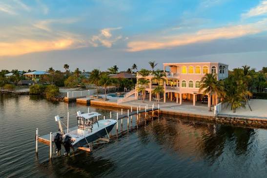 Waterfront mansion with private dock at sunset